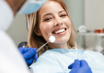 Blonde woman smiling during dental cleaning