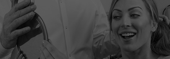 Woman looking at smile in mirror black and white