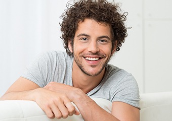 person sitting on couch and smiling