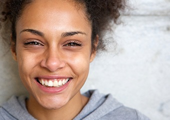 person against a wall smiling