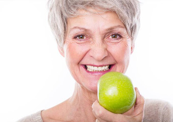 Senior woman holding a green apple