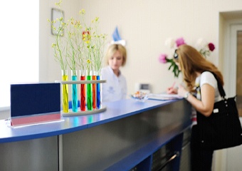 Woman filling out forms at dental reception desk