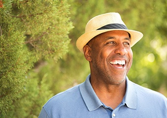 older man in blue polo smiling with dentures in Columbia