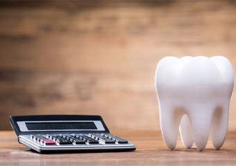 Tooth and calculator on a wooden table