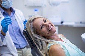 A smiling woman preparing to receive dental care