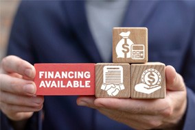 a person holding wooden blocks that have financing logos on them