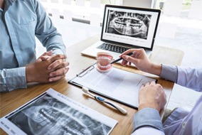 a dentist speaking with a patient about a treatment plan