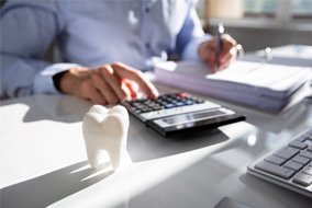 a person calculating the cost of dental implants