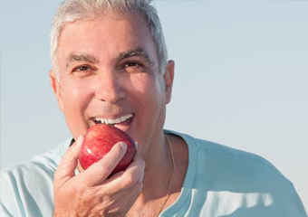 Older man eating apple