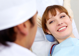 Red-haired woman smiling at dentist after root canal therapy in Columbia, TN