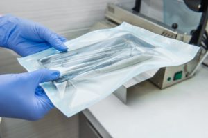 dentist placing dental instruments into a sterilizer