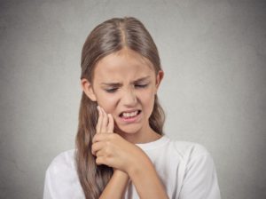 Girl with toothache needing to see dentist in Columbia