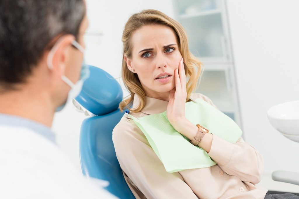 Woman at the dentist after experiencing a knocked-out tooth.