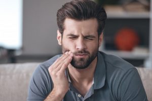 Pained man with a sensitive dental implant in Columbia 