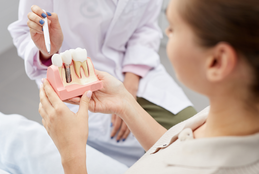 Dentist showing patient dental implant model