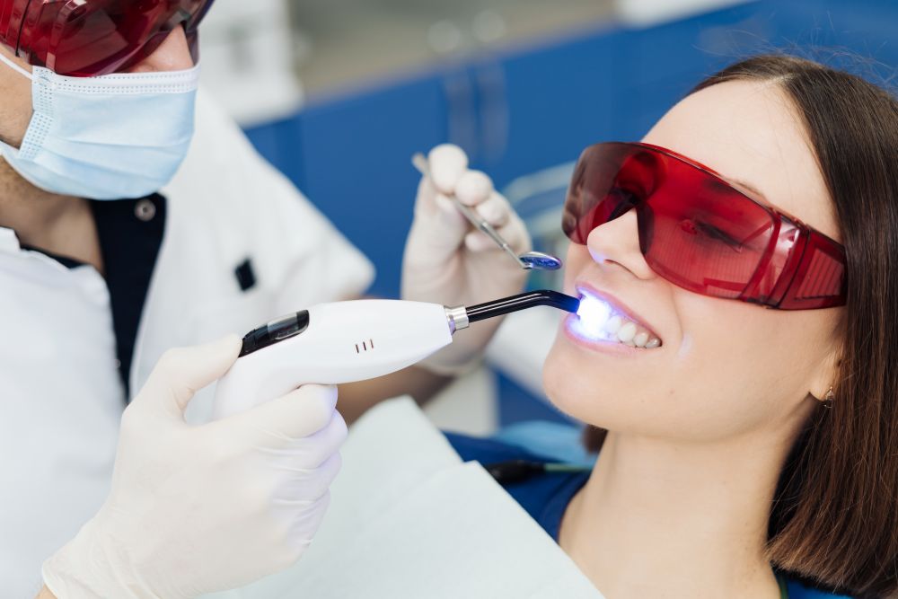 A woman getting professional teeth whitening from a dentist